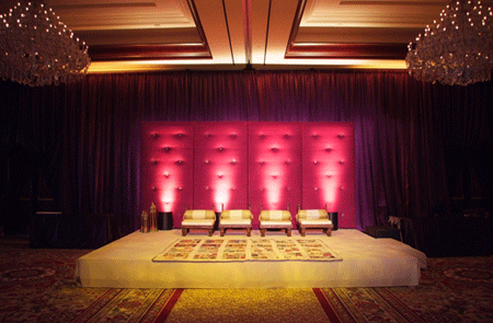 Purple and pink stage background with cream colored chairs