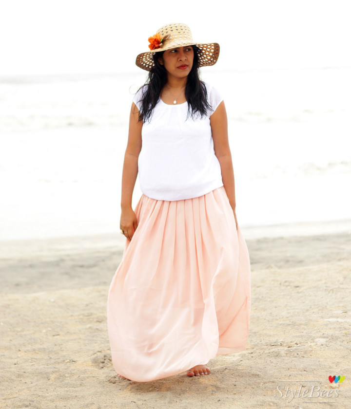 Beach fashion in peach maxi skirt and sunhat